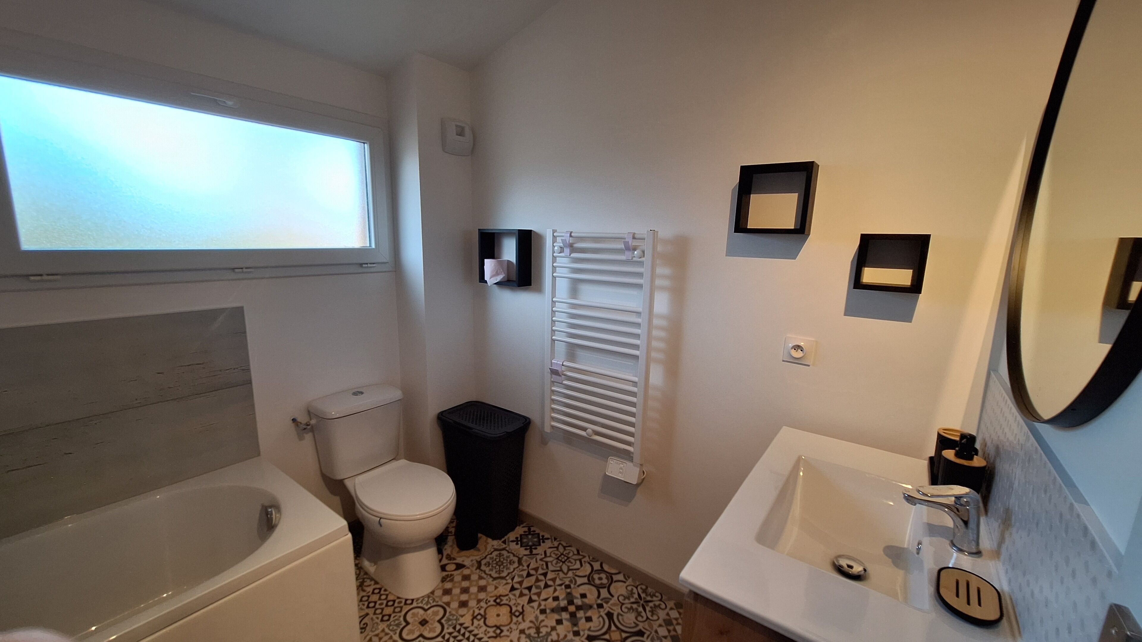 A bathroom with a bathtub, toilet, sink, and a towel rack.