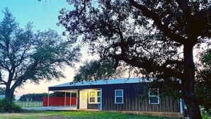 Une maison moderne de plain-pied, dotée d’un toit plat, d’un porche abrité et d’une cour clôturée.