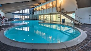 En indendørs swimmingpool med en central ø, en trappe og udsigt til øvre plan.