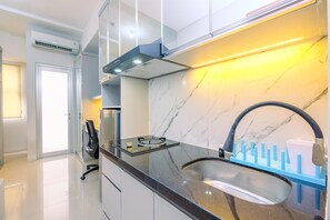 Deluxe Apartment | Private kitchen | Full-size fridge, stovetop, rice cooker, cookware/dishes/utensils - Elegant And Homey Studio Apartment Transpark Juanda Bekasi Timur (Bekasi)