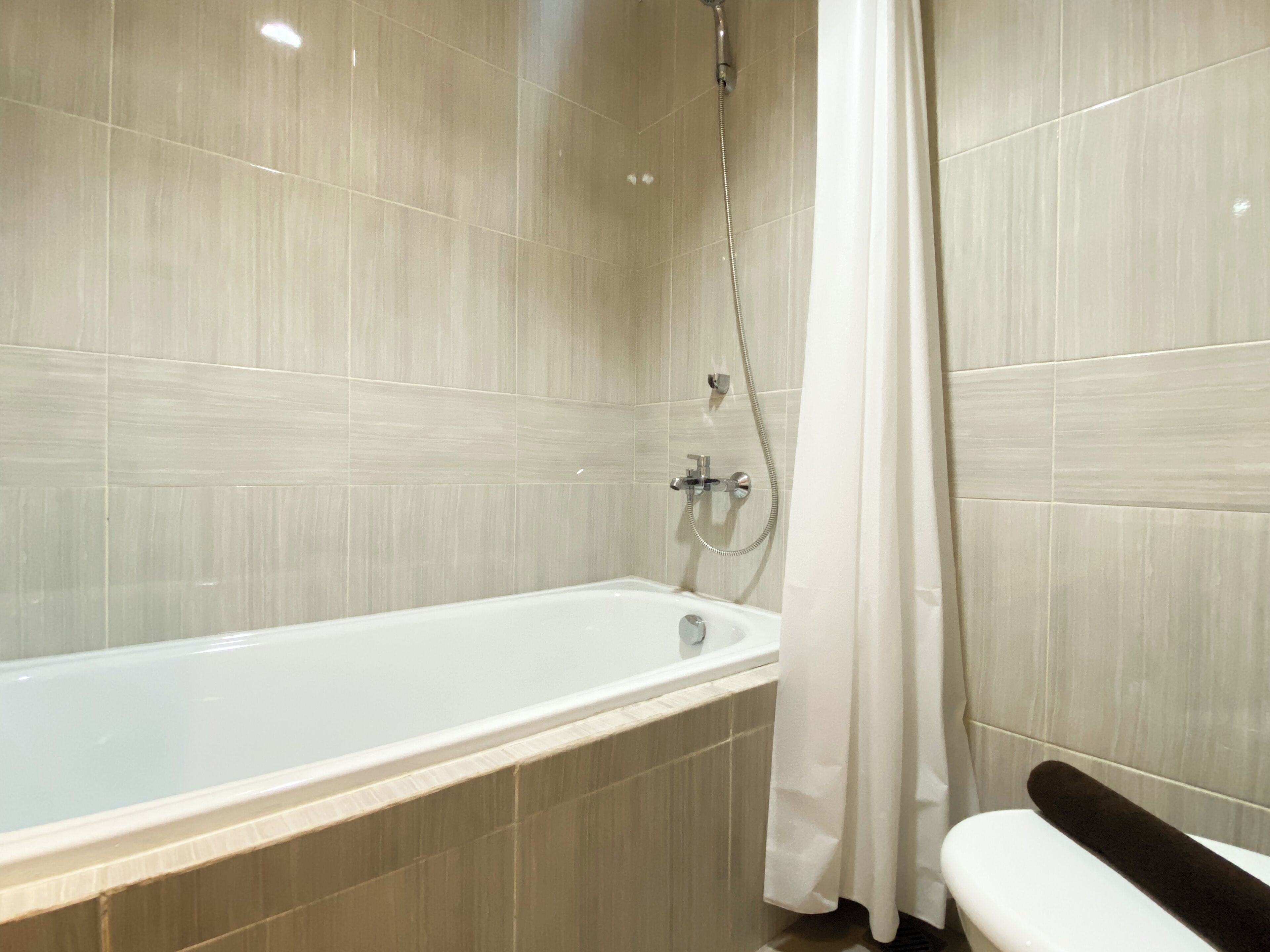 Une salle de bain moderne équipée d’une baignoire, d’une douche et de toilettes.
