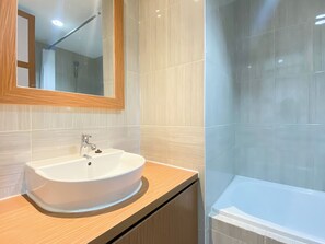 Deluxe-Apartment | Badezimmer | Badewanne und Dusche (separat), Handtücher, Shampoo