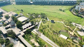 An aerial view of a modern building complex with multiple structures, green spaces, and a large parking area. - Nice And Cozy Studio Apartment At Vasanta Innopark (Cikarang)