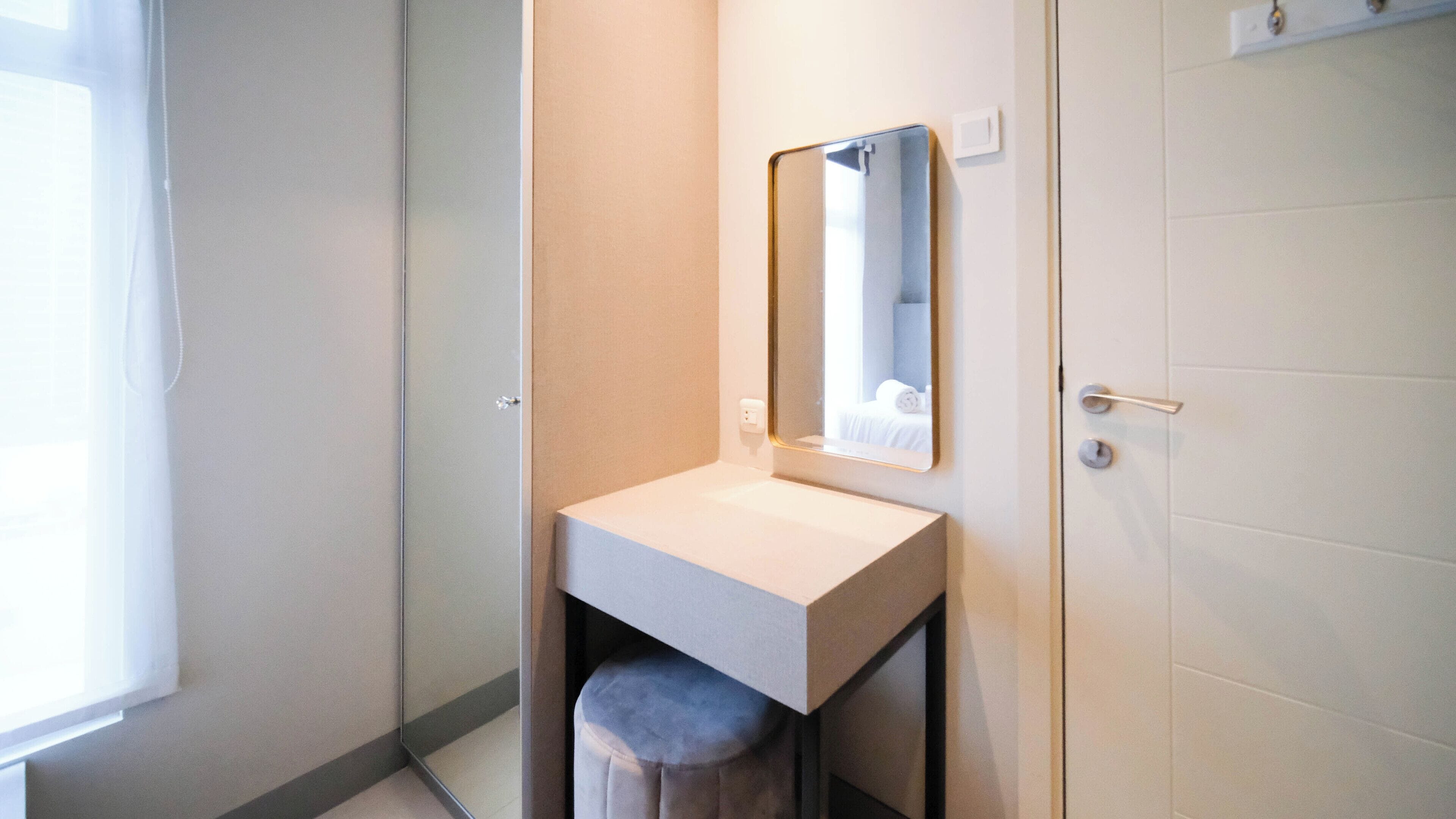 A bathroom with a white sink, a mirror, and a towel hanging on the wall.