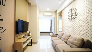 Ein modernes Wohnzimmer mit Fernseher, einer Couch und einer Wand mit Muster.