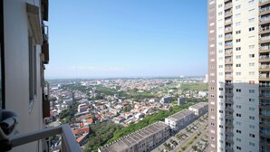 A high-rise building with a view of a densely populated cityscape.