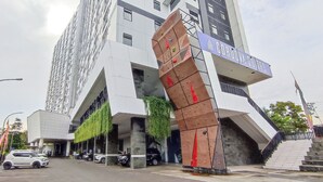 A modern hotel with a distinctive angular entrance and a sign for 'CORONIA SULTENS'. - Comfy And Modern Studio At Cordova Edupartment Semarang Apartment (Semarang)