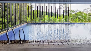 A pool with a metal railing and a view of greenery. - Comfy And Modern Studio At Cordova Edupartment Semarang Apartment (Semarang)