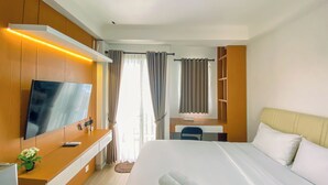 A hotel room with a bed, a TV, a desk, and a chair. - Minimalist Studio Apartment Signature Park Grande (Jakarta)