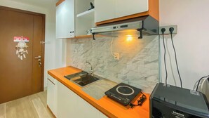 A kitchen with a countertop, sink, and a built-in oven. - Minimalist Studio Apartment Signature Park Grande (Jakarta)