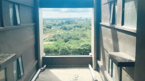 A narrow corridor with a view of a green landscape and a distant structure. - Comfortable Designed And Best Deal 2Br At Meikarta Apartment (Cikarang)