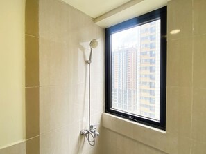 Deluxe appartement | Badkamer | Een douche, handdoeken, shampoo