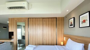 A hotel room with a bed, a desk, a chair, and a wardrobe. - Spacious And Elegant Studio Apartment Mustika Golf Residence (Cikarang)