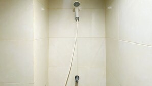 A shower with a handheld showerhead and a wall-mounted faucet. - Cozy Stay Studio (No Kitchen) Elvis Tower Apartment (Cikarang)
