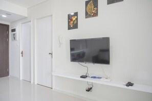 Enjoy a clean and functional space with a flat-screen TV, console table, and convenient electrical outlet.