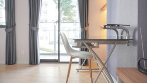 A modern room with a desk, chair, and large window with curtains. - Brand New And Comfy Studio At Daan Mogot City Apartment (Jakarta)