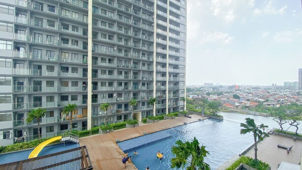 A high-rise building with a swimming pool and a view of a cityscape.