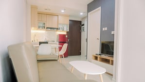 A modern living room with a sofa, a small table, and a TV.