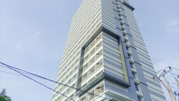 Un edificio alto y moderno con fachada de entramado y balcones.
