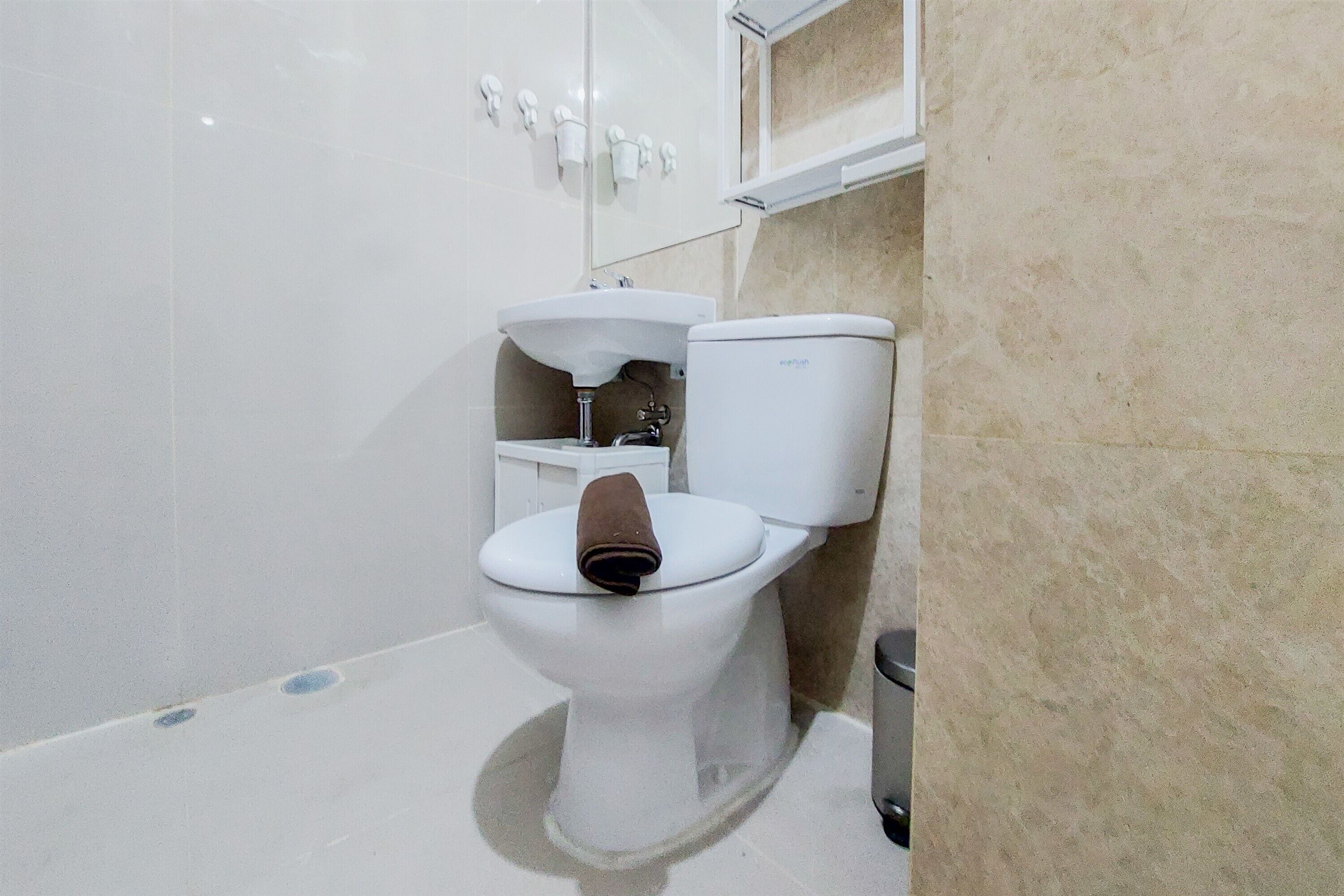 A bathroom with a toilet, sink, and a towel rack.