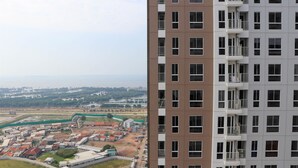 A high-rise building with multiple balconies and a view of a coastal area with buildings and greenery. - Restful And Cozy 2Br Tokyo Riverside Pik 2 Apartment (Teluknaga)