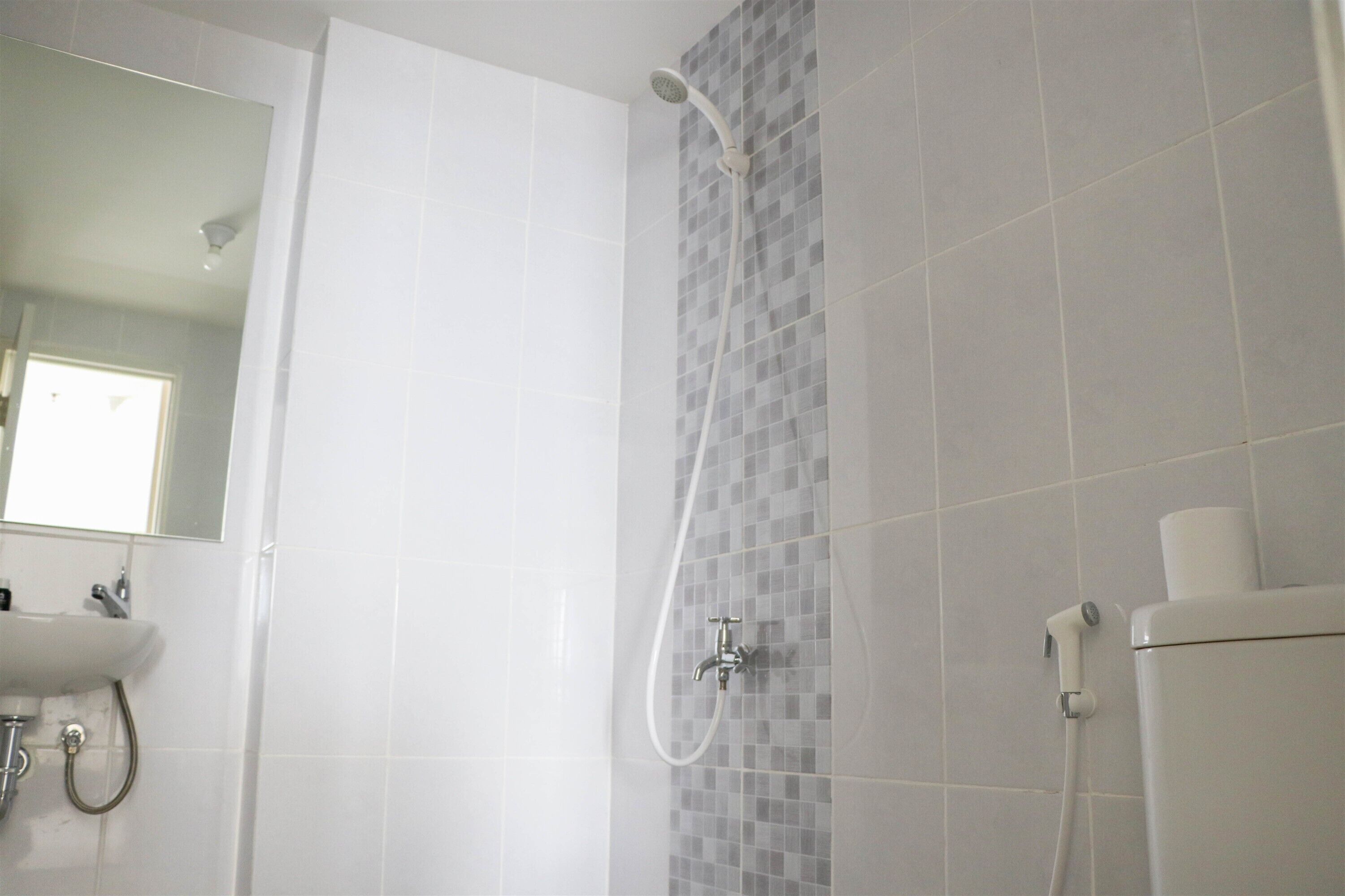 Ein Badezimmer mit Dusche, Waschbecken und Toilette.