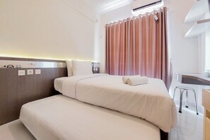 Ein Hotelzimmer mit Bett, Schreibtisch und Stuhl.