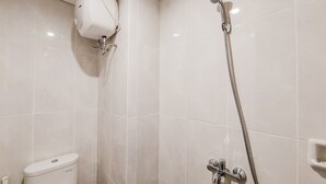 Een badkamer met toilet, douche met handdouche en luchtzuiveraar aan de muur.