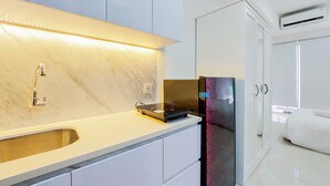 Una cucina moderna con lavello integrato, piano cottura a induzione nero e frigorifero in acciaio inossidabile.