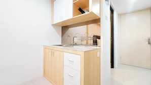 Una cocina compacta con armarios de madera, un lavamanos y una encimera.
