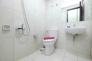 Bathroom features a toilet, sink, and handheld showerhead.