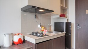 A modern kitchen with a built-in stove, a sink, and a refrigerator. - Brand New And Comfort Studio At Vasaka Solterra Apartment (Jakarta)
