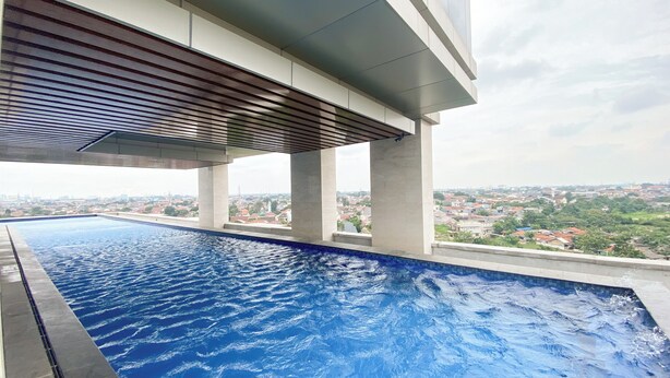 An infinity pool with a view of a cityscape. - Brand New And Comfort Studio At Vasaka Solterra Apartment (Jakarta)