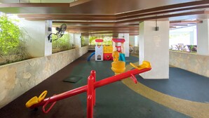 An indoor play area with a seesaw, climbing structures, and a fan. - Best Deal And Homey 2Br Bassura City Apartment (Jakarta)