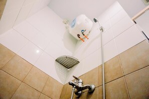 A bathroom with a white tiled floor, a shower with a handheld showerhead, and a toilet with a visible water tank. - Comfort Stay 2Br At Green Pramuka City Apartment (Jakarta)