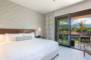 A modern hotel room with a large bed, a nightstand, a lamp, and a view of a balcony with outdoor furniture. - KLVR presents Honua Kai Luana Villa 1C*Ocean Views (Lahaina)