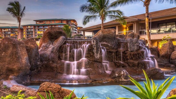 A hotel with a waterfall feature, large rocks, and a pool. - KLVR welcomes you to Luana Garden Villa 1C upper level with partial ocean view  (Lahaina)