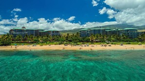 A beachfront hotel with multiple buildings, a sandy beach, and clear turquoise water. - KLVR welcomes you to Luana Garden Villa 1C upper level with partial ocean view  (Lahaina)
