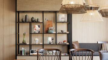 A modern interior with a wooden bookshelf, a dining table, and chairs.