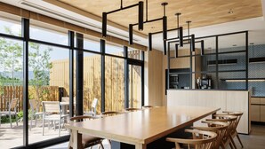A modern kitchen with a large island, wooden chairs, and a dining table.