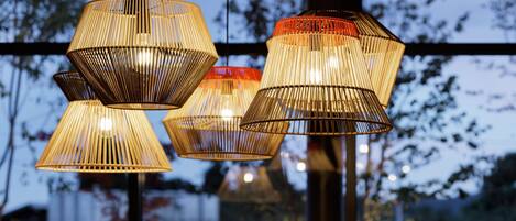 A series of hanging lamps with a woven design, suspended from a ceiling.