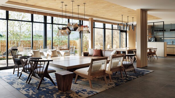 A spacious living area with a large dining table, comfortable seating, and a view of the outdoors.