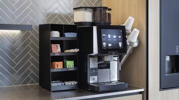Een koffieapparaat met een digitaal scherm, een koffiemolen en een koffiepers.