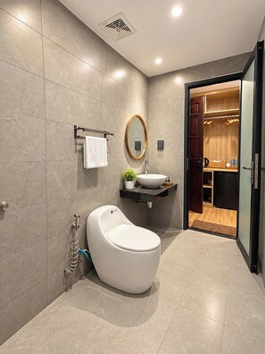 Un baño moderno con inodoro, lavamanos y espejo.