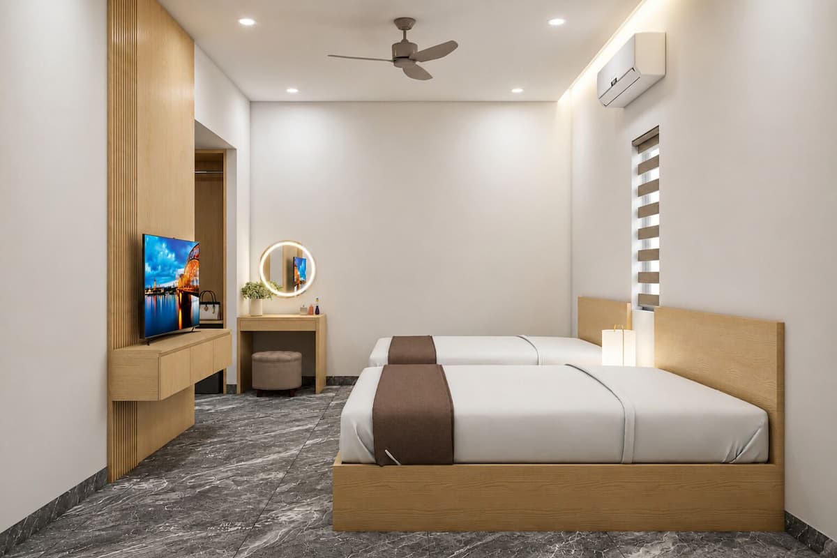 Une chambre d’hôtel avec un lit, un bureau doté d’un miroir, une télévision et un ventilateur de plafond.