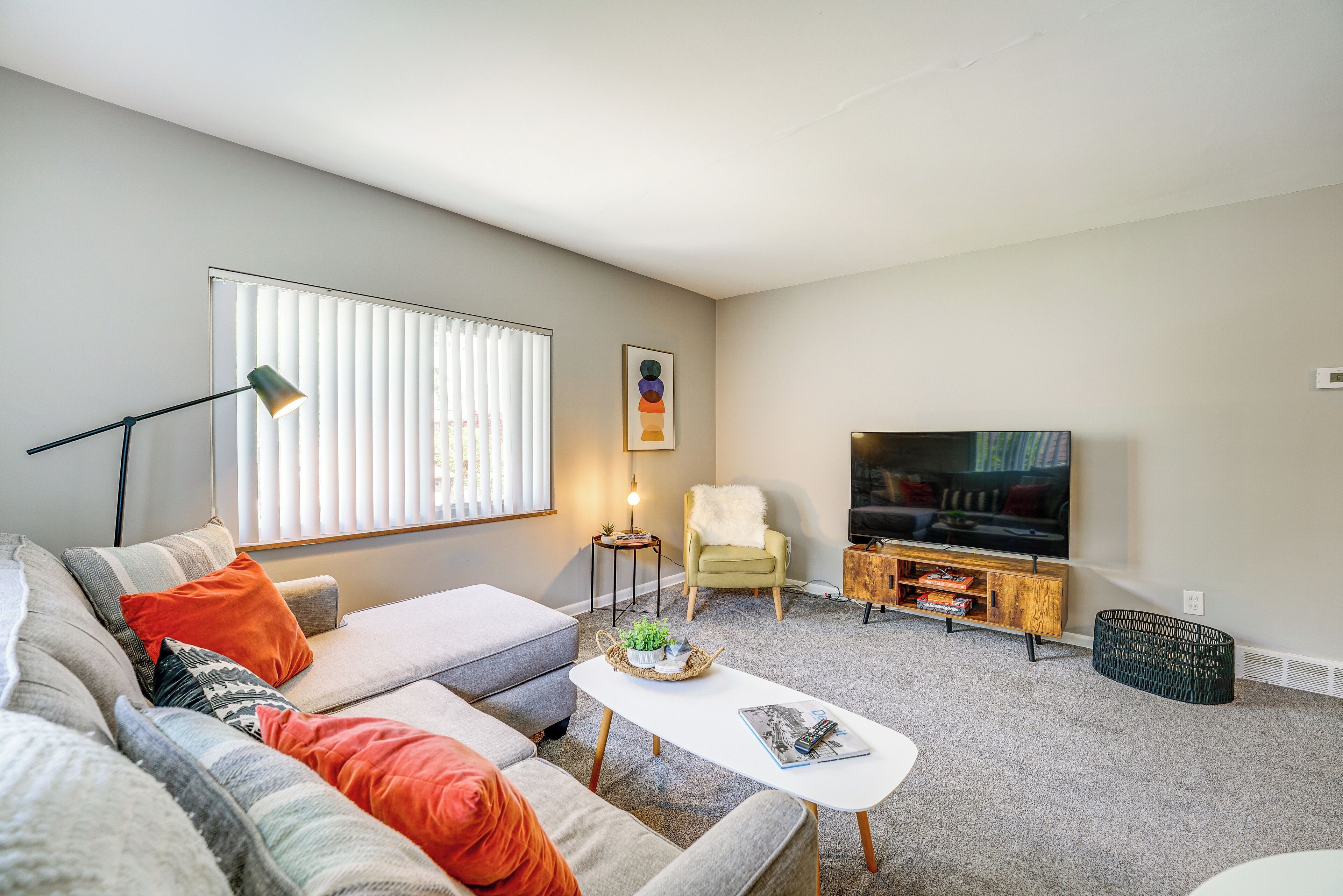 Ein Wohnzimmer mit Sofa, Couchtisch, Fernseher und Sessel.