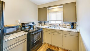 A compact kitchen with a built-in oven, microwave, and sink. - Pet-Friendly Wyandotte Apt Near Bishop Park! (Wyandotte)