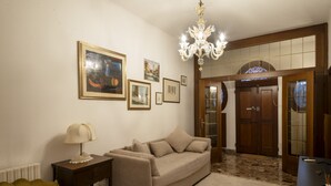 A living room with a sofa, a lamp, and framed pictures on the wall. - Ca dei Ferro - MURANO Island, beautiful Venetian apartment with private terrace  (Venezia)
