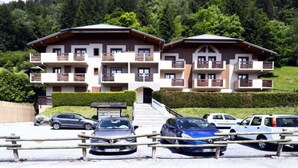 Un hotel moderno con edifici a due piani, balconi e un'area parcheggio.