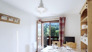 Zona pranzo con tavolo apparecchiato per quattro, televisione e vista sull'esterno.